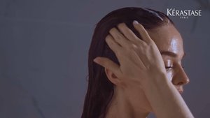 Mujer aplicandose shampoo humectante anticaspa